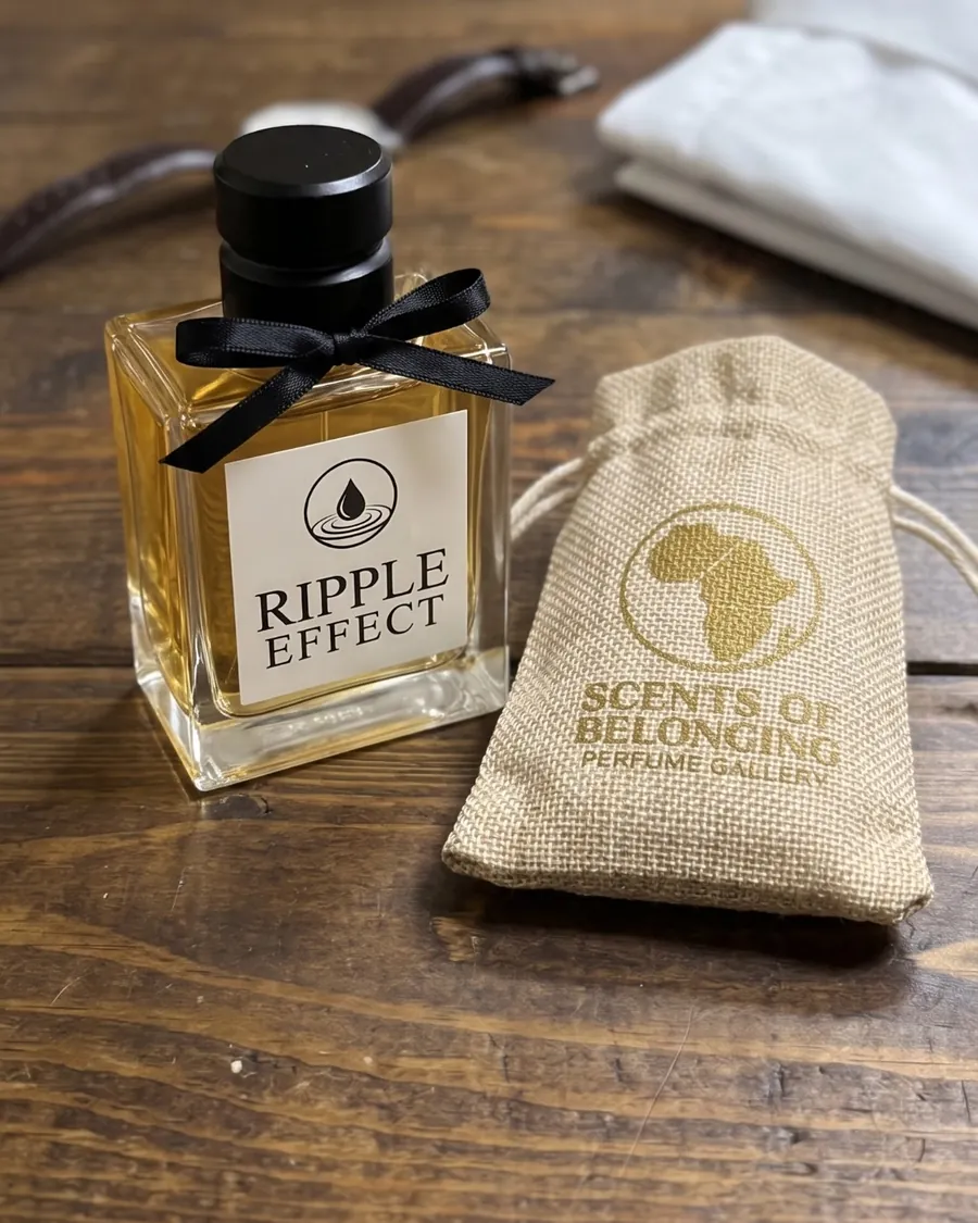 The Ripple Effect bottle with a black ribbon beside its jute pouch